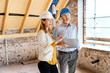 © peter scholl/Westend61 - Businesswoman explaining to engineer standing with digital tablet at construction site