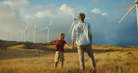 father and son with windmills on golden hillside at sunset, dreaming of a clean and sustainable futu