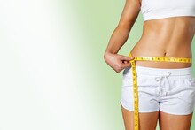 Slim Young Woman Measuring Her Thin Waist