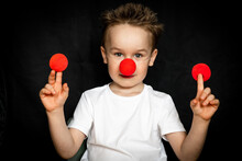 Boy With A Clown Red Nose And Red Noses In His Hands. Red Nose Day.