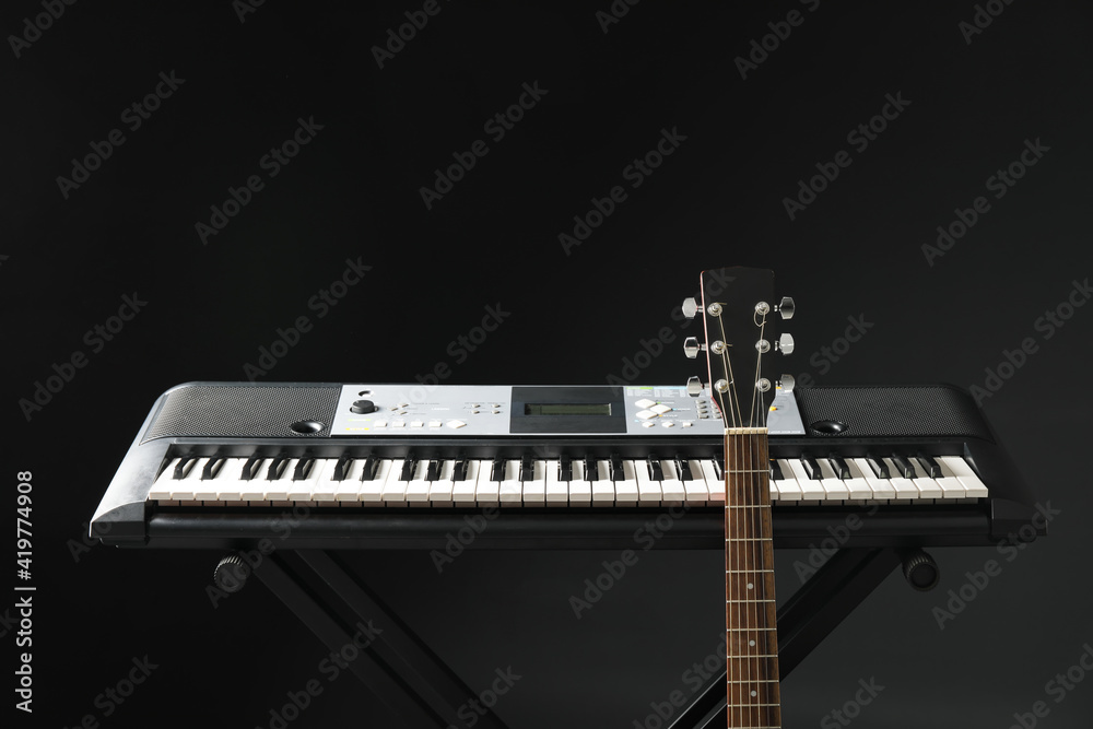 Acoustic guitar and synthesizer on dark background