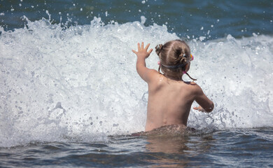 The boy swims in the water