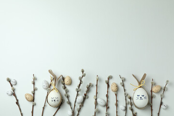 Easter eggs, quail eggs and catkins on white background