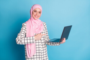 Wall Mural - Photo of young happy girl indicate finger computer ad promotion recommendation advice isolated over blue color background