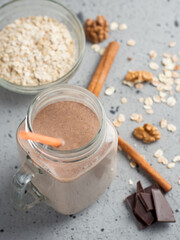 Wall Mural - Glass jar of milkshake smoothie with chocolate, coffee, oatmeal and nuts