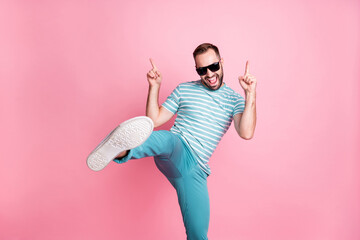 Portrait of nice naughty cheerful funky guy dancing having fun wear sunglasses showing sole isolated over pink pastel color background