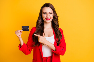 Poster - Portrait of her she nice-looking attractive glamorous cheerful wavy-haired lady holding in hands demonstrating bank card isolated on bright vivid shine vibrant yellow color background