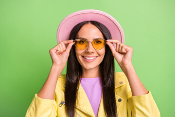 Sticker - Photo portrait of amazed cheerful hispanic woman touching yellow sunglass smiling isolated on bright green color background