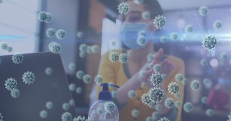 Poster - Multiple covid-19 floating against woman wearing face mask sanitizing her hands at office