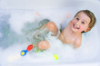 © Anna - Little boy playing with toy by taking  bath in bathtub. Smiling toddler  sitting in bathtub with lot of fluffy soap bubble and smiling. Daily routine with children.