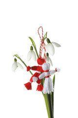 Beautiful snowdrops with traditional martisor on white background. Symbol of first spring day