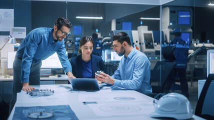 Wall Mural - Factory Office Meeting Room: Team of Engineers Gather Around Conference Table, They Discuss Project Blueprints, Inspect Mechanism, Find Solutions, Use Laptop. Industrial Technology Factory