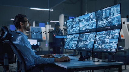 Poster - Industry 4.0 Modern Factory: Security Operator Controls Proper Functioning of Workshop Production Line, Uses Computer with Screens Showing Surveillance Camera Feed. High-Tech Security