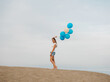 © Irina Magrelo - Young woman holding blue and white helium balloons
