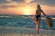 © aleonovs - Young beautiful adult sexy blonde model pose in the black bikini with huge hat  and taking fun at dramatic sunset