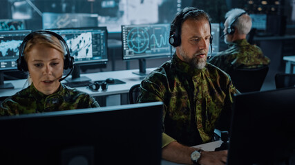 Fototapete - Military Surveillance Team of Officers in Headsets Working in a Central Office Hub for Cyber Operations, Control and Monitoring for Managing National Security, Technology and Army Communications.