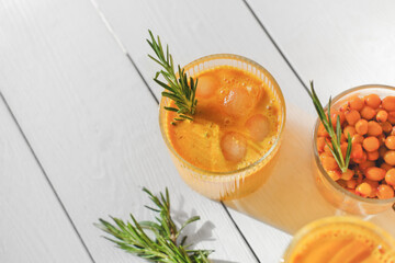 Wall Mural - raw sea buckthorn juice in glasses. with rosemary. antioxidant drinkfor immunity boost in spring. vitamin juice for healthy life