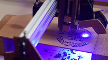 Laser Cnc Machine Cutting Canadian Cedar Wood And Making A Circle Ornament Motif. Laser Cut Process With Blue Laser. Close-up. 