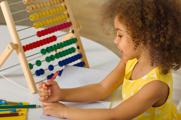A Black  girl is ready for a math and arithmetic lesson with an abacus.