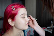 © vkfoto - pink-haired girl with three gold earrings starts to do makeup