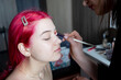© vkfoto - pink-haired girl with three gold earrings starts to do makeup