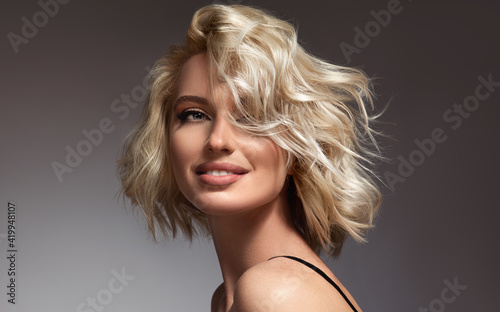 Beautiful model girl with short hair .Beauty woman with blonde  curly hair.  Hair dye .Fashion, cosmetics and makeup