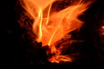 Poster - A flame of burning coal bursts out of the hole between the masses of coal.