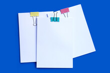 Stacking Of Business Document With Colorful Binder Clips On Blue Background.