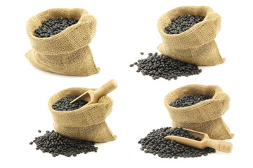 Wall Mural - dried black beans in a burlap bag with a wooden scoop on a white background