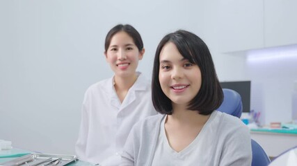 Wall Mural - Portrait of Caucasian female patient smiling, and sitting with dentist