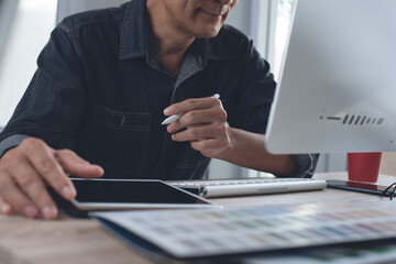 Man graphic designer working on computer and digital tablet at office