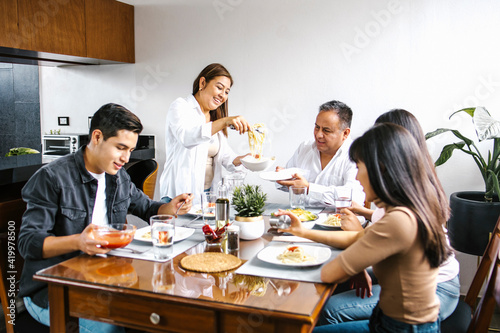 latin family eating pasta together in home in Mexico city