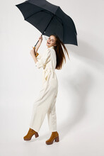Cheerful Woman Holding An Umbrella In Her Hands White Jumpsuit Fashion Studio Boots