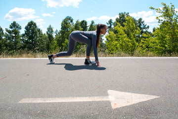 Athletic woman on track starting to run. Jogging girl. Arrow direction sign.