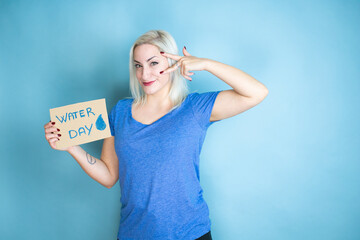 Young beautiful woman asking for the environment holding banner with water day message Doing peace symbol with fingers over face, smiling cheerful showing victory