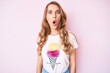 © Krakenimages.com - Young caucasian woman with blond hair wearing casual summer clothes scared and amazed with open mouth for surprise, disbelief face