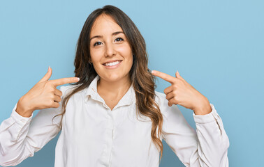 Wall Mural - Young brunette woman wearing casual clothes smiling cheerful showing and pointing with fingers teeth and mouth. dental health concept.