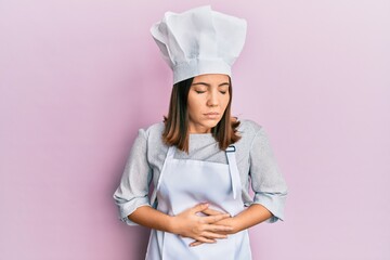 Canvas Print - Young beautiful woman wearing professional cook uniform and hat with hand on stomach because indigestion, painful illness feeling unwell. ache concept.