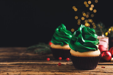 Delicious cupcakes with green cream on wooden table. Space for text