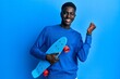© Krakenimages.com - Young african american man holding skate screaming proud, celebrating victory and success very excited with raised arm