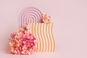 Wall Mural - pink arch, wooden plate with waves and flowers on a pink background. stylish background with various