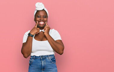 Canvas Print - Young african woman with turban wearing hair turban over isolated background smiling with open mouth, fingers pointing and forcing cheerful smile