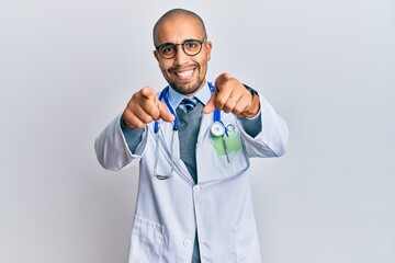 Sticker - Hispanic adult man wearing doctor uniform and stethoscope pointing to you and the camera with fingers, smiling positive and cheerful