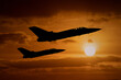 Fighter jets silhouettes at sunset, interceptor military aircraft on a combat mission to intercept foreign aeroplanes. 