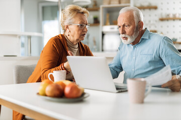 Wall Mural - Angry mature couple arguing about their home finances at home