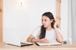 © shapovalphoto - Young girl student video chatting or online calling, sit at the table with laptop