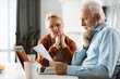 © Goran - Old couple going through their finances together at home