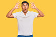 © Krakenimages.com - Young arab man wearing casual clothes looking surprised and shocked doing ok approval symbol with fingers. crazy expression