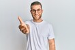 © Krakenimages.com - Young caucasian man wearing casual clothes and glasses smiling friendly offering handshake as greeting and welcoming. successful business.