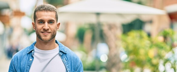 Young caucasian man smiling happy standing at the city.